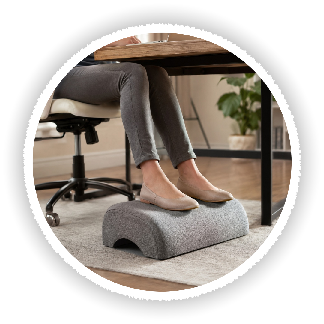 Person using a footrest at a desk in an office setting
